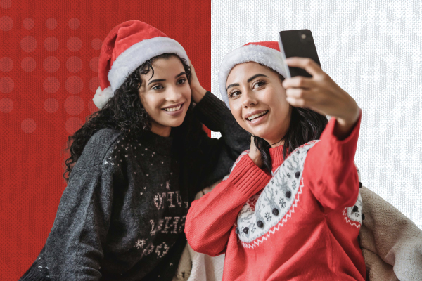 Abuela sonriendo mientras recibe una videollamada de su familia en el extranjero durante la temporada navideña.